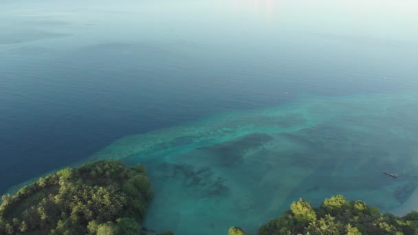 熱帯アイ島白砂浜バンダ諸島マルクインドネシア緑豊かな緑の森ターコイズウォーターサンゴ礁の夕日の空の上を飛ぶ ネイティブシネのようなD Logカラープロファイル — ストック動画
