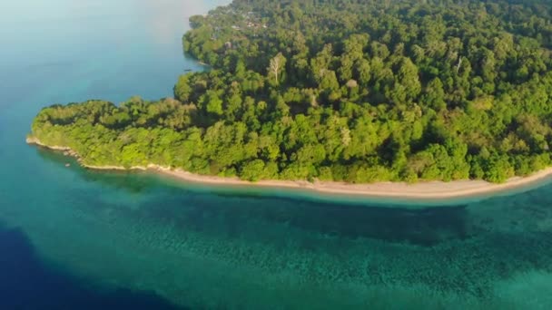 航空写真 熱帯アイ島白砂浜バンダ諸島マルクインドネシア緑豊かな緑の森ターコイズウォーターサンゴ礁の夕日の空の上を飛ぶ — ストック動画