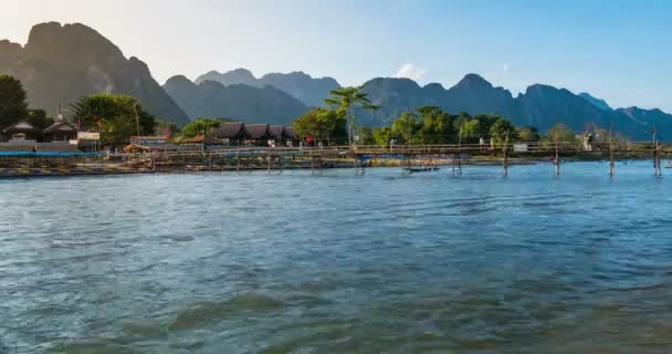 방 비엥, 라오스 - 2019년 2월경: 라오스의 인기 여행지인 방비엥(Vang Vieng)에서 강을 타고 나무 다리를 걷는 시간 경과 관광객들 — 비디오