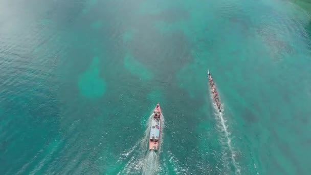 Εναέρια: κορυφή προς τα κάτω Κόρα-Κόρα παραδοσιακό κανό ετήσιο αγώνα στην Bandaneira στην πανέμορφη θάλασσα των νησιών μπάντα, Μαλούκου, Ινδονησία. Εγγενή προφίλ χρώματος D-log — Αρχείο Βίντεο