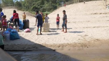 Luang Prabang, Laos - yaklaşık Şubat, 2019: Luang Prabang yakınlarındaki Mekong nehir kıyısında tekne bekleyen yerel yoksul insanlar, Laos