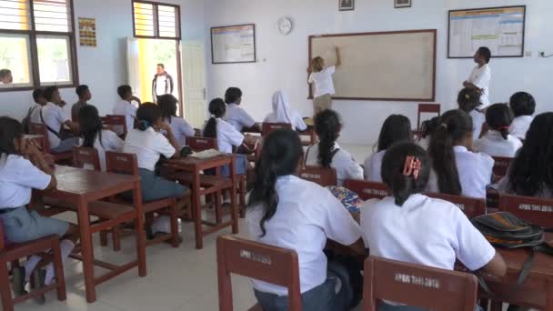 Wab, indonesien - ca. oktober 2018: ein ausländischer europäischer lehrer, der an einer indonesischen schule im abgelegenen dorf wab, kei-inseln, molukken unterrichtet — Stockvideo