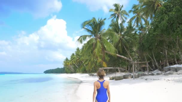 Slow motion: kvinna sola promenader på vit sandstrand turkos vatten tropisk kustlinje WAB Kei Islands Indonesien paradis resmål solig varm dag — Stockvideo