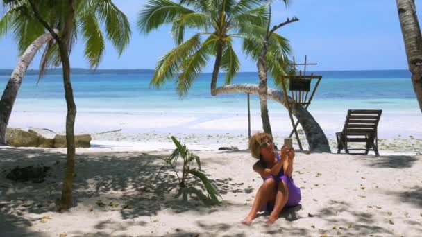 Žena se selfie pomocí telefonu na tropické bílé písečné pláži palmy karibské moře Wab Kei ostrovy Indonésie. Turista na dovolené v inspirativní cestovní destinaci slunný horký den