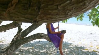 Tropikal beyaz kumsal palmiye ağaçları üzerine kitap okuyan kadın Kei Adaları Endonezya 'yı gölgeliyor. Sıcak, güneşli bir günde, ilham verici bir seyahatte turist.