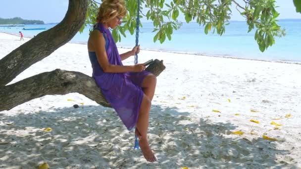 Woman Reading Ebook Tropical White Sand Beach Palm Trees Shade — 비디오