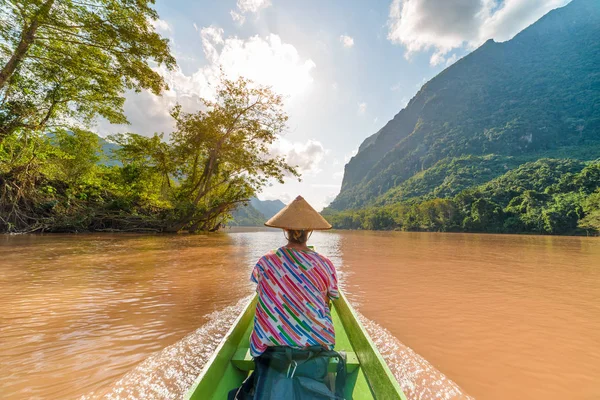 Mujer con sombrero tradicional de crucero en el agua marrón del río Nam Ou en Laos, increíble paisaje montaña selva famoso destino de viaje en el sudeste de Asia vista trasera — Foto de Stock