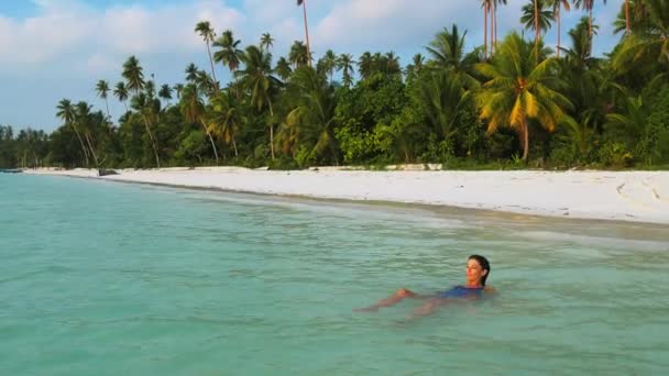 女子日光浴在绿松石水白沙滩热带海岸线帕西尔潘强基岛印度尼西亚天堂旅游目的地日落光 — 图库视频影像
