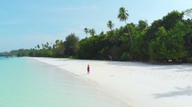 Havadan yavaş hareket: Kadın beyaz kum plaj turkuaz su tropikal kıyı şeridi Pasir Panjang Kei Adaları Endonezya Moluccas Maluku Endonezya doğal seyahat hedef yürüyüş