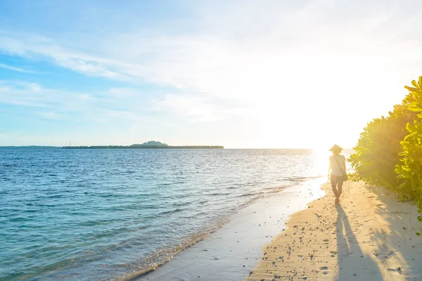 Mujer con sombrero asiático tradicional relajante en la playa tropical en la luz de fondo al atardecer personas reales. Indonesia, Islas Banyak, Sumatra destino de viaje . — Foto de Stock