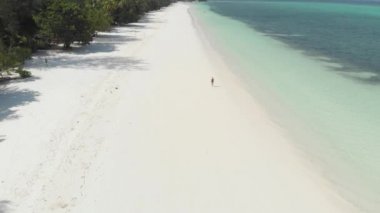 Andan: Kadın beyaz kum plaj turkuaz su tropikal kıyı şeridi Pasir Panjang Kei Adaları Endonezya Moluccas Endonezya doğal seyahat hedef yürüyüş. Yerli cinelike D-log renk profili