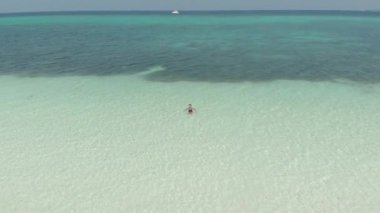 Hava: Kadın beyaz kum plaj turkuaz su tropikal kıyı şeridi Pasir Panjang Kei Adaları Endonezya Moluccas Maluku Endonezya seyahat hedef rahatlatıcı. Yerli cinelike D-log renk profili