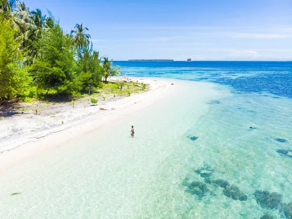 Aérea: Mujer saliendo del mar caribeño de agua turquesa arrecife de coral tropical caminando en la playa de arena blanca. Islas Banyak Sumatra Indonesia pintoresco destino de viaje — Foto de Stock