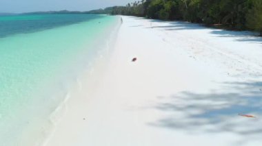 Havadan yavaş hareket: Kadın beyaz kum plaj turkuaz su tropikal kıyı şeridi Pasir Panjang Kei Adaları Endonezya Moluccas Maluku Endonezya seyahat hedef rahatlatıcı