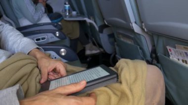 Kadın uçak, seyahat tatil teknoloji kavramı içinde oturan ebook okuma