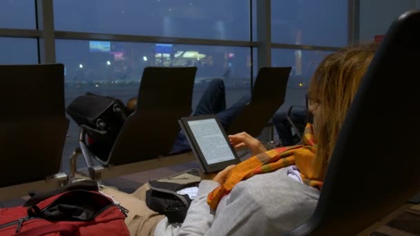 Havaalanı Terminal Salonunda Oturan Ebook Okuyan Kadın Seyahat Tatil Teknolojisi — Stok video