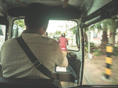Kamboçya'da tuk tuk'a binen pov tanınmaz bir adam. Güney Doğu Asya'da ucuz ulaşım modu. Suburst backlight.