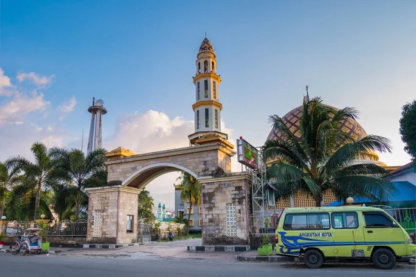 Ambon, Indonésia - 7 de outubro de 2018: mesquita de rua e mini van angkot verde na cidade de Ambon, Molucas, Indonésia . Fotos De Bancos De Imagens