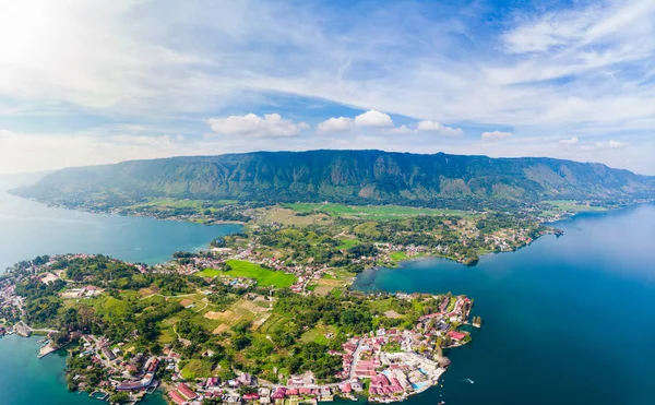 Aéreo: Lago Toba e Samosir Island vista de cima Sumatra Indonésia. Caldeira vulcânica enorme coberta por água, aldeias tradicionais de Batak, arrozais verdes, floresta equatorial. — Fotografia de Stock