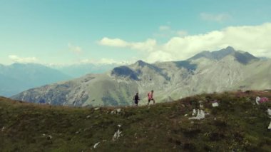 Havadan yavaş çekim: dağ tepesinde yürüyüş çift backpackers, doğal manzara. Alpler'de yaz maceraları. Fetih başarı olgun yetişkin eğlenceli refah fitness sahip