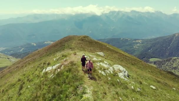 空中慢动作 情侣背包客在山顶徒步旅行 风景秀丽 阿尔卑斯山的夏季探险 征服成功成熟成人有乐趣健康健身 — 图库视频影像