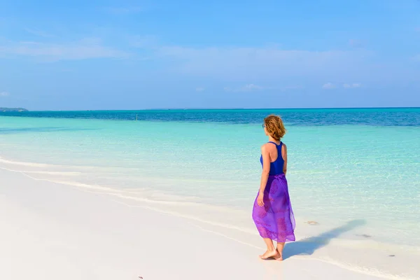 Mujer caminando en la playa tropical. Vista trasera arena blanca playa turquesa transparente agua caribe mar personas reales. Indonesia Islas Kei Molucas destino de viaje. — Foto de Stock