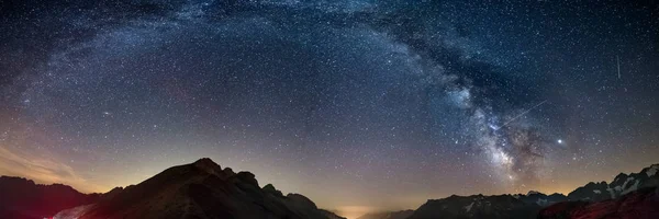 알프스, 마시프 데 에크린, 브라이언콘 세르 슈발리에 스키 리조트, 프랑스에 있는 은하수 아치별 하늘. 파노라마 뷰 하이 산맥과 빙하, 천체 사진, 별 관측 로열티 프리 스톡 이미지