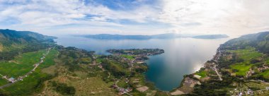 Hava: Toba Gölü ve Sumatra Endonezya 'dan Samosir Adası manzarası. Büyük volkanik kaldera suyla kaplı, geleneksel Batak köyleri, yeşil pirinç tarlaları, ekvatoral orman.