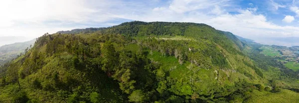 空中：托巴湖和萨摩亚岛，从苏门答腊岛上空俯瞰。被水覆盖的巨大火山口、传统的巴塔克村庄、绿色稻田、赤道森林. — 图库照片