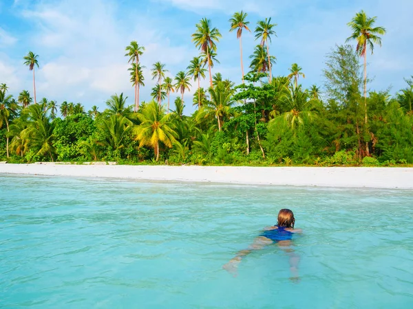 Frau schwimmt im karibischen Meer türkisfarbenes, transparentes Wasser. Tropischer Strand auf den Molukken der Kei-Inseln, Sommerreiseziel in Indonesien. — Stockfoto