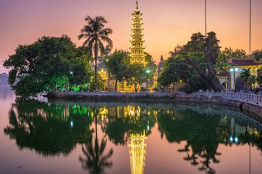 Hanoi Budist pagoda Batı Gölü, renkli günbatımı, ışıklı tapınak, su yansıması. Chua Tran Quoc Üzerinde Ho Tay Hanoi, Vietnam seyahat.