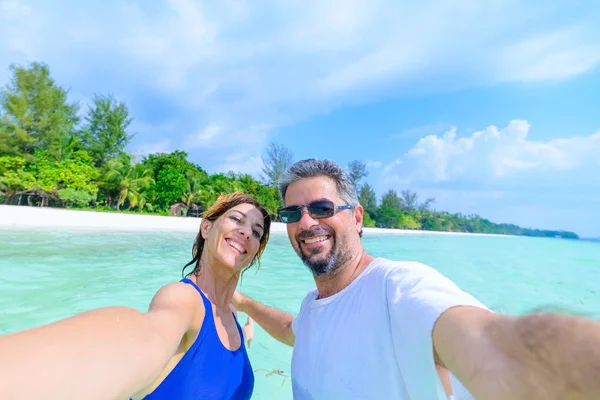 Feliz hombre y mujer tomando selfie en el mar tropical caribeño. Adulto de mediana edad viajando pareja, personas reales divirtiéndose en vacaciones . —  Fotos de Stock