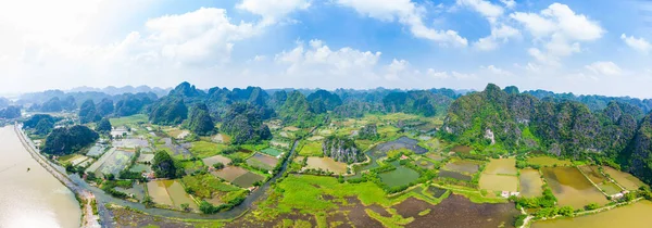 Widok z powietrza na region Ninh Binh, Trang An Tam Coc atrakcją turystyczną, UNESCO Światowego Dziedzictwa UNESCO, malownicza rzeka czołgająca się przez krasowe pasma górskie w Wietnamie, cel podróży. — Zdjęcie stockowe