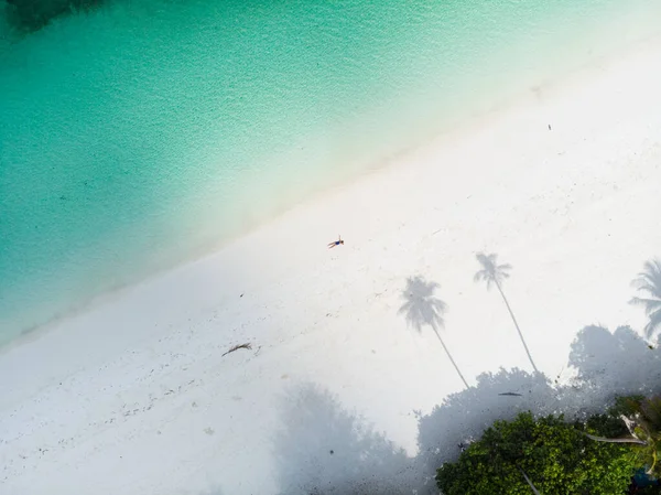 Antenne von oben nach unten Blick tropischen Strand Karibik Meer. Frau sonnt sich zwischen Palmen Schatten auf weißem Sandstrand türkisfarbenem Wasser. Exotischer Urlaub. — Stockfoto