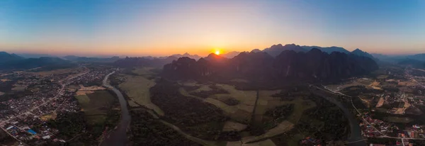 Hava: Vang Vieng backpacker seyahat hedef Laos, Asya. Günbatımı pirinç paddies Vadisi, peyzaj çarpıcı doğal kayalıklarla ve rock pinnacles, üzerinde. — Stok fotoğraf