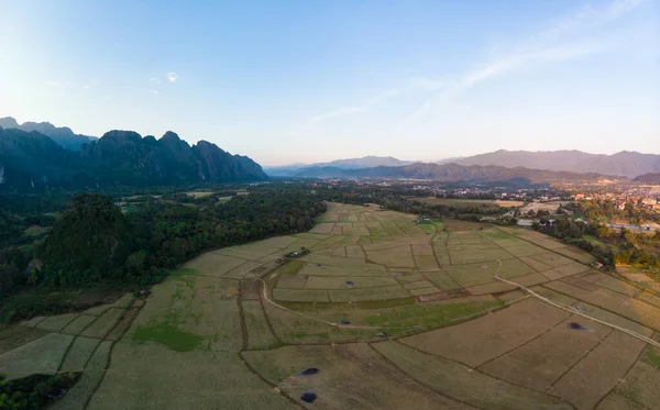 Antena: Vang Vieng backpacker cel podróży w Laosie, Asia. Zachód słońca nad malownicze klify i skalne szczyty, ryżu ryżowych valley, wspaniałych krajobrazów. — Zdjęcie stockowe