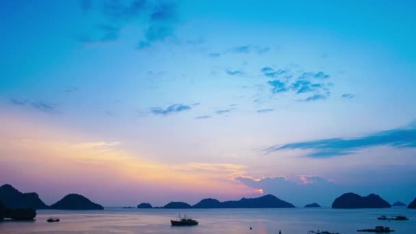 時間の経過 海に浮かぶ漁船と日没のベトナム猫バ湾 雲の多い熱帯の天気 カラフルな空と島のプロフィール地平線で — ストック動画