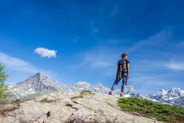 山の上にバックパックを持つ女性 風光明媚な高山の風景を見て一人夏休みフィットネス幸福の自由の概念 — ストック写真