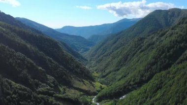 Hava aracı, İtalya Alpleri 'ndeki yemyeşil bir vadi ve dağ deresi üzerinde uçuyor. Turizm gezisi için açık hava aktivitesi. Torino, Piedmont, İtalya