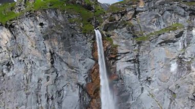Hava ağır çekim: İnsansız hava aracı yüksek şelalenin üzerinde uçuyor, İtalya Alpleri 'ndeki yüksek kayalık kayalıklardan dağ akıntısı düşüyor. Torino yakınlarındaki Pi Şelalesi, Piedmont, İtalya