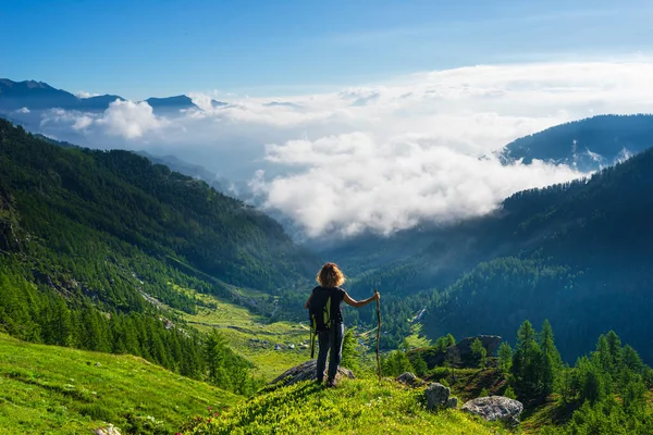 女人躺在山顶上 凝视着山谷上壮观的风景云彩 清澈的蓝天 暑期活动健康幸福自由成功 — 图库照片