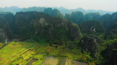 Hava: Günbatımında Kuzey Vietnam karst manzarası, Ninh Binh bölgesinin insansız hava aracı görüntüsü, Trang An Tam Coc turizm merkezi, UNESCO Dünya Mirası Alanı, eşsiz kireçtaşı zirveleri ve pirinç tarlaları