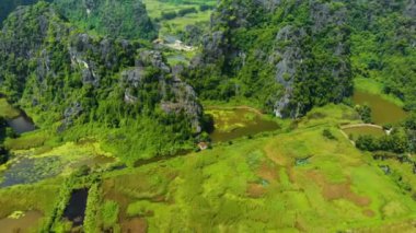 Hava: Günbatımında Kuzey Vietnam karst manzarası, Ninh Binh bölgesinin insansız hava aracı görüntüsü, Trang An Tam Coc turizm merkezi, UNESCO Dünya Mirası Alanı, eşsiz kireçtaşı zirveleri ve pirinç tarlaları