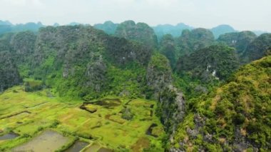 Hava: Günbatımında Kuzey Vietnam karst manzarası, Ninh Binh bölgesinin insansız hava aracı görüntüsü, Trang An Tam Coc turizm merkezi, UNESCO Dünya Mirası Alanı, eşsiz kireçtaşı zirveleri ve pirinç tarlaları