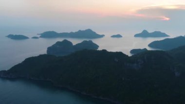 Günbatımında Cat Ba ve Ha Long Bay kaya tepelerinin üzerinde uçmak, Vietnam 'daki ünlü turizm merkezi. Eşsiz kireçtaşı zirveleri ve denizdeki adalar, manzaralı körfezler ve yeşil orman.