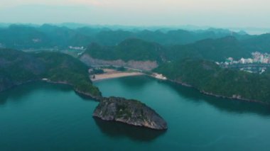 Akşam karanlığında Cat Ba adasının üzerinde uçan Ha Long Bay 'in Vietnam' daki ünlü turizm merkezi. Manzaralı plaj ve burunlar arasında su koyları.