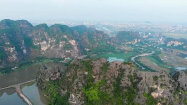 Hava: Kuzey Vietnam karst manzarası, Ninh Binh bölgesinin insansız hava aracı manzarası, Trang An Tam Coc turizm beldesi, eşsiz kireçtaşı zirveleri, pirinç tarlaları, nehir ve köyleri geçen yol.