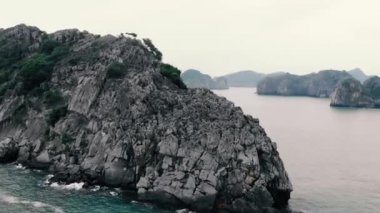 Günbatımında Cat Ba ve Ha Long Bay kaya tepelerinin üzerinde uçmak, Vietnam 'daki ünlü turizm merkezi. Eşsiz kireçtaşı zirveleri ve denizdeki adalar, manzaralı körfezler ve yeşil orman.