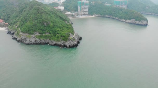 공중에서 아름다운 바위가 해안선을 날면서 하롱만에 절벽에 산책로 — 비디오