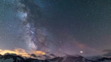 Zaman Hızı: Samanyolu Galaksisi ve yıldızlar görkemli İtalyan Fransız Alpleri üzerinde dönerler. Güzel karlı dağlarda ve buzullarda gece gökyüzü. Yörüngedeki uçak ve uydular.